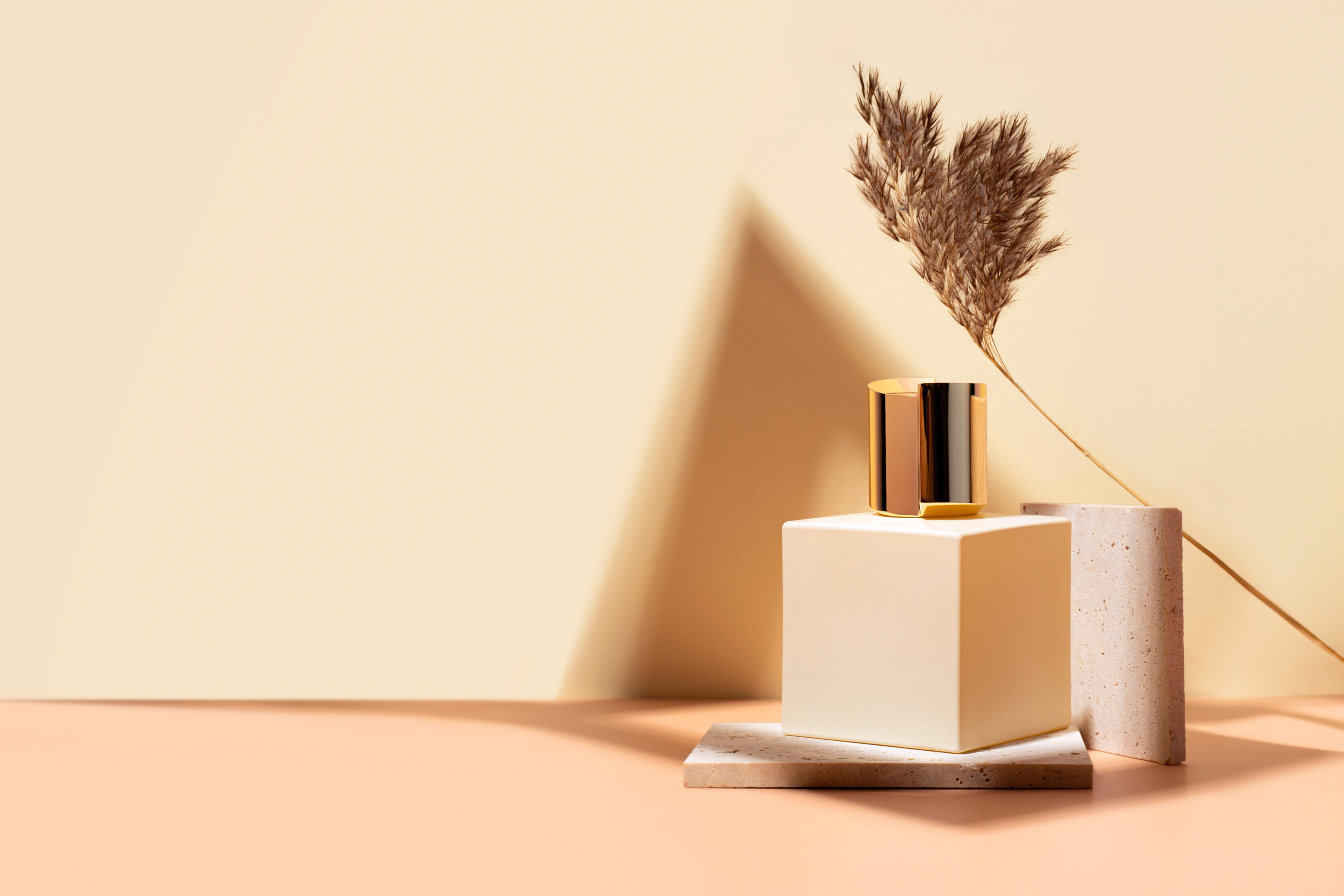 Kirov 27 March 2022 Nishane Hacivat, niche luxury perfumery boutique, perfume fragnance in glass vial, standing on a a podium made of travertine on a sand colored background. Still life.